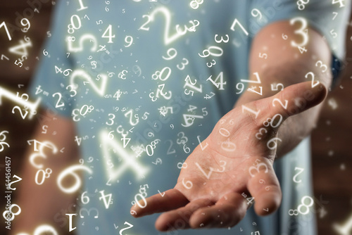 numerology, young man holds out his hand, surrounded by numbers photo