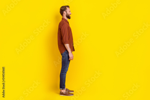 Full size profile photo of cheerful positive person look empty space isolated on yellow color background