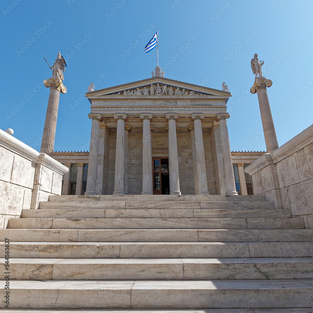 White marble stairs to the academy of Athens' main building with Athena and Apollo statues. Culture travel in Athens, Greece.
