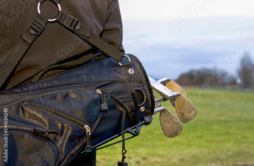Golfclubs in black bag on back of golfer photo