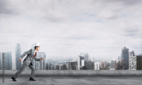 King businessman in elegant suit running on building roof and business center at background © adam121