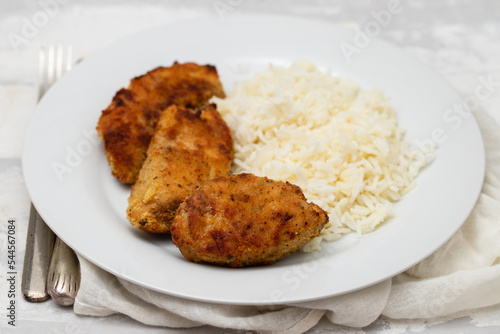 Delicious crispy fried breaded chicken breast strips with boiled rice