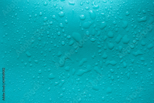 Water drops on a turquoise leather surface as an abstract background