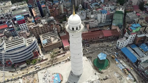 A circling aerial view of the Dharahara Tower with the city of Kathmandu, Nepal in the background with its pollution and haze. photo