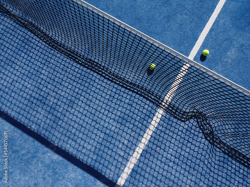 aerial drone view of balls on a blue paddle tennis court © VicVaz