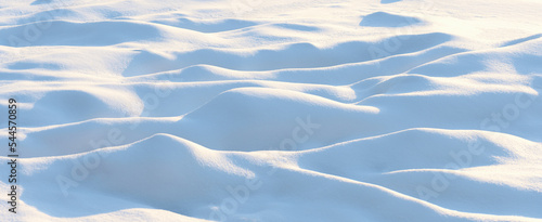 Natural winter background with snow drifts and falling snow
