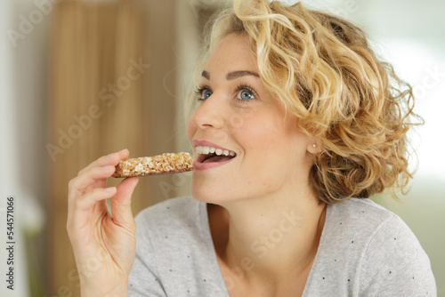 woman eating grain cereal bar