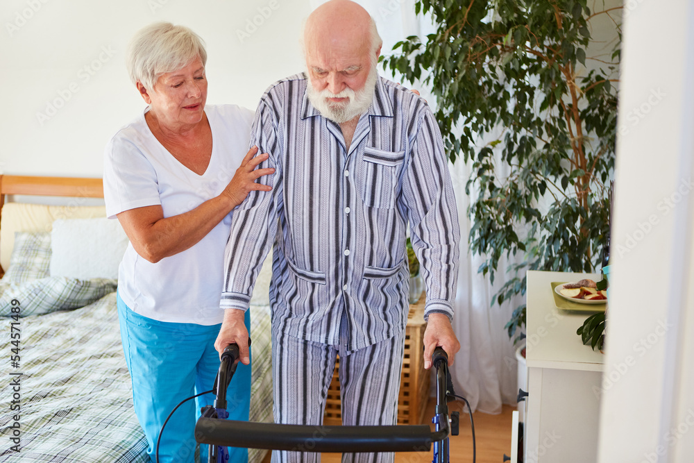 Geriatric nurse supports senior citizens walking after a stroke