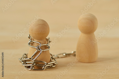 Photographie Wooden pawn with chains controlled by his partner - Concept of toxic relationshi