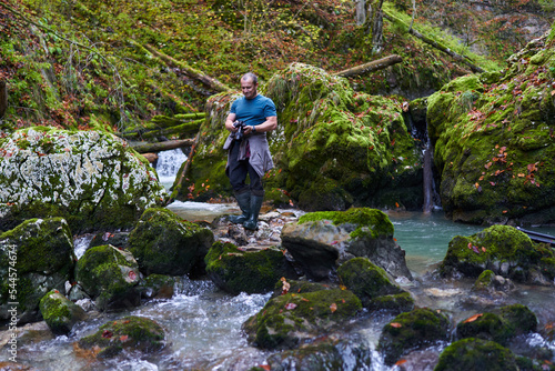 Photographer shooting landscapes in a gorge with a river