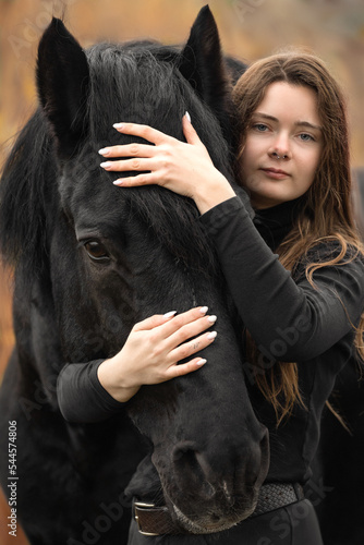 Portrait of beautiful girl with black stallion