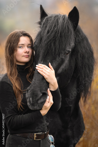 Portrait of beautiful girl with black stallion