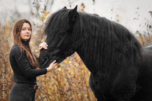 Portrait of beautiful girl with black stallion