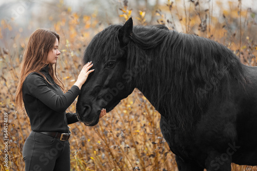 Portrait of beautiful girl with black stallion