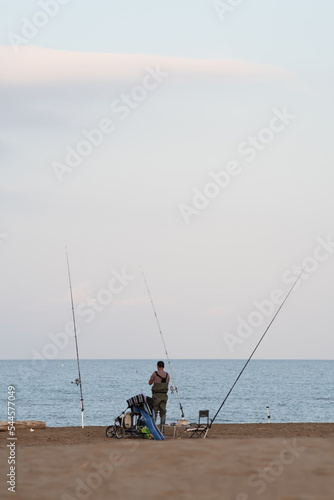 fisherman fishing on the shore of the beach