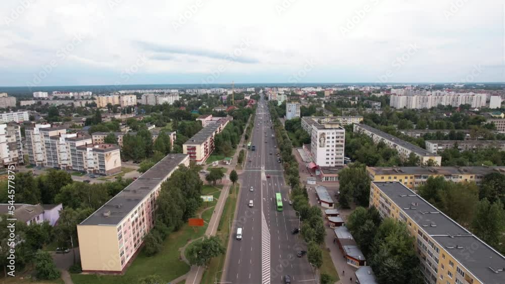 Aerial view of city blocks immersed in greenery and the central road with heavy traffic Aerial view of city blocks immersed in greenery and the central road with heavy traffic