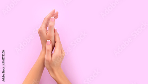 female hands with french manicure on pink background