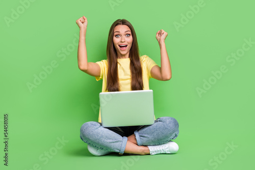 Photo of astonished positive stylish lady raise hand fist rejoice pass online exam shout hooray yes isolated on green color background © deagreez