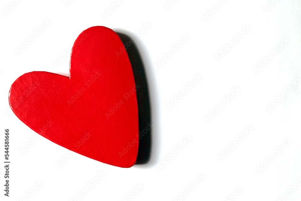 Red lacquered heart shaped box on the left of a white surface with copy space on the right. Horizontal. Red lacquered heart shaped box on the left of a white surface with copy space on the right. Horizontal.