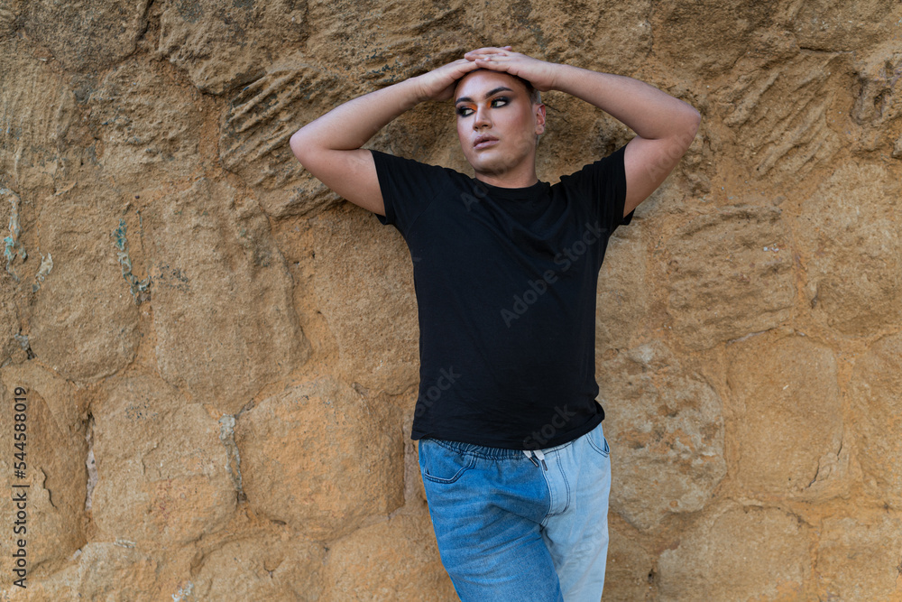 Portrait of a Latin American non-binary person, looking away while posing leaning against a wall. Concept of gender and ethnic diversity. Portrait of a Latin American non-binary person, looking away while posing leaning against a wall. Concept of gender and ethnic diversity.