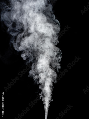 A stream of white smoke streams and rises against a black