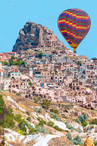 Hot air balloon flying over spectacular Cappadocia, Uchisar castle in the background - Goreme, Turkey