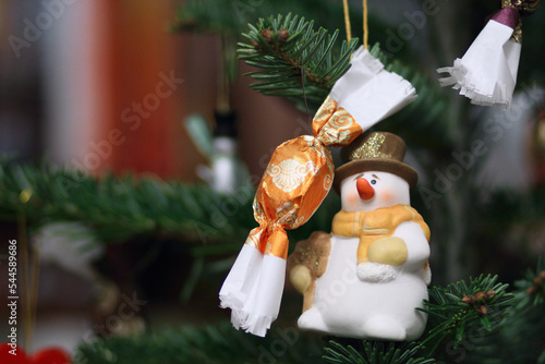 Christmas decoration on a tree, a little snowman and Hungarian szaloncukor