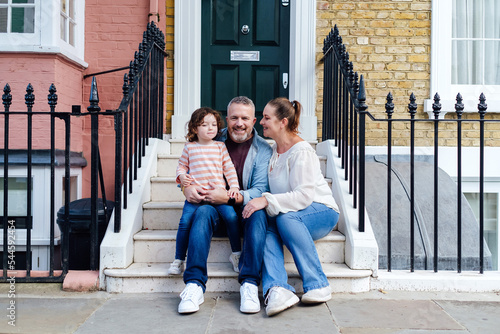 Family sitting together on front step of their house