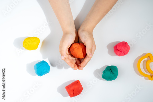 children's hands with plasticine, the development of fine motor skills and speech in children, top view, on a white background