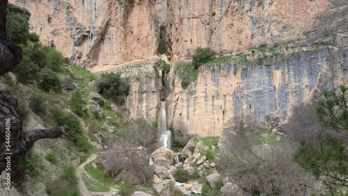 Panoramic view of waterfall and Mediterranean forest. Aerial travelling out. photo