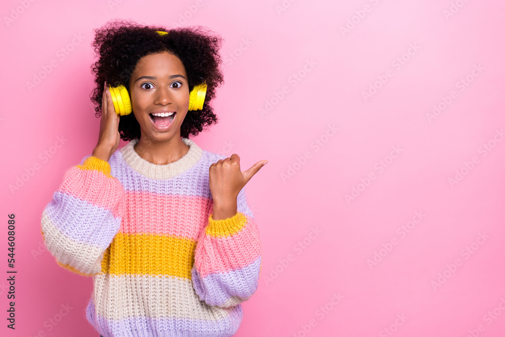 Photo of impressed excited girl perming coiffure knit sweater touch headphones indicating empty space isolated on pink color background Photo of impressed excited girl perming coiffure knit sweater touch headphones indicating empty space isolated on pink color background