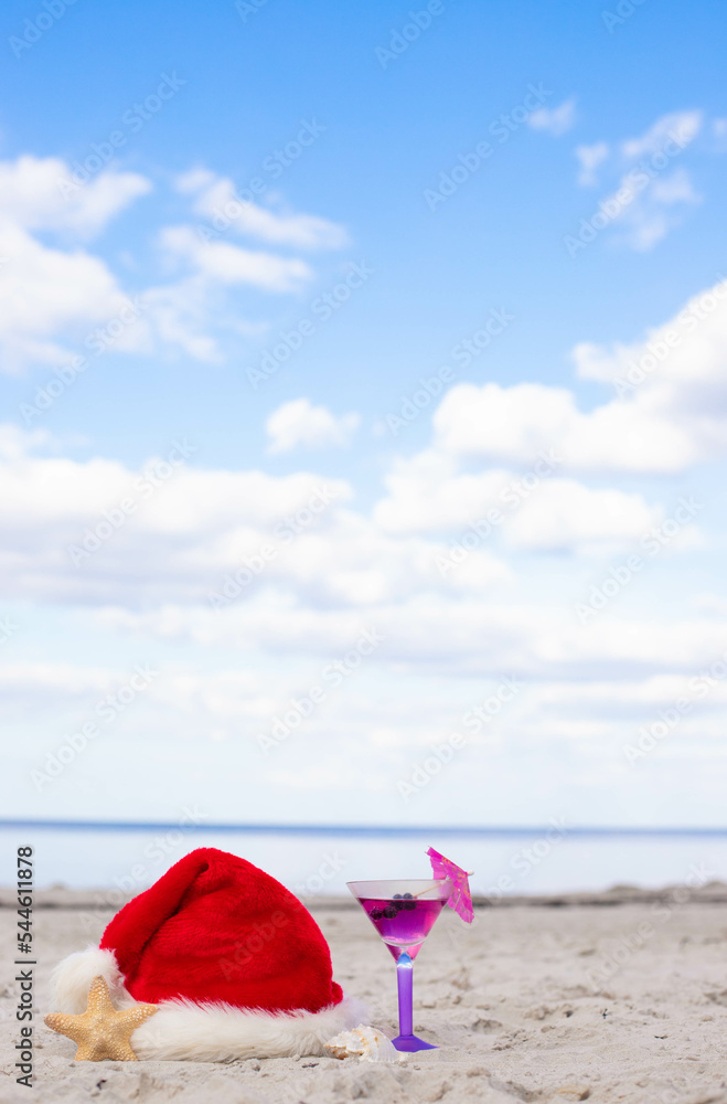 Santa Claus hat on the beach with starfish and cocktail 