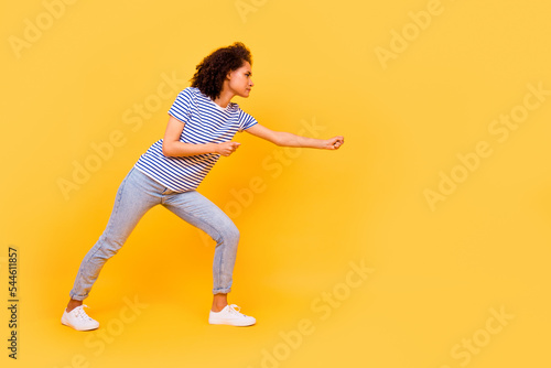 Full length profile photo of focused concentrated person arms hold pull empty space rope isolated on yellow color background photo