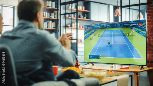 Photography At Home Tennis Fans Sitting on a Couch Watch Game on TV