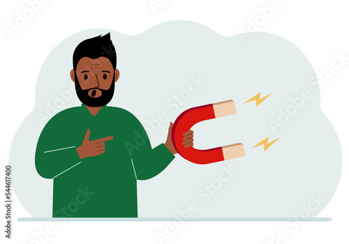 A man holds a huge magnet in his hand, attracts new customers, money and ideas. Inbound business marketing technologies, lead generation concept.