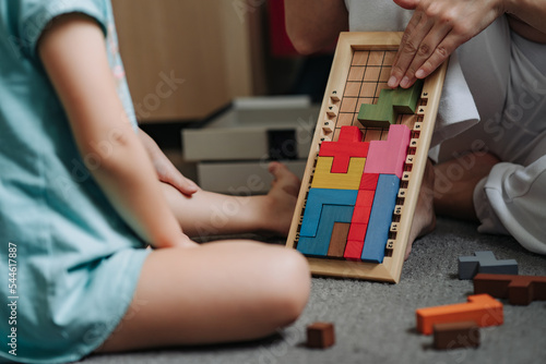 Board puzzle game. Mom with Child playing a Board game. Educational games for children. Development of spatial thinking in kids.