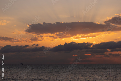 Orange sunset sky and sun over the sea. Water surface and outlines on the horizon. © Kozlik_mozlik