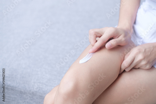 hands skin protection. closeup asia woman applying protective cream on leg