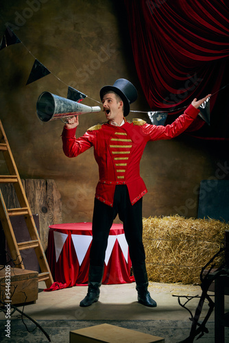 Konstfotografi Vintage portrait of male retro circus entertainer expresses rejoice and announces start of show over dark retro circus backstage background