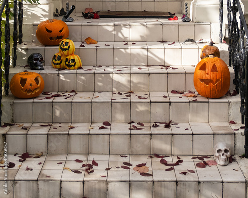 Halloween decorations of traditional english house. Funny carved pumpkins and skeleton on the doorstep.