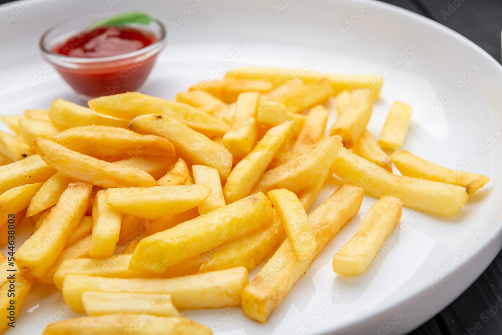 Appetizing side dish - French fries with ketchup in a white plate Appetizing side dish - French fries with ketchup in a white plate