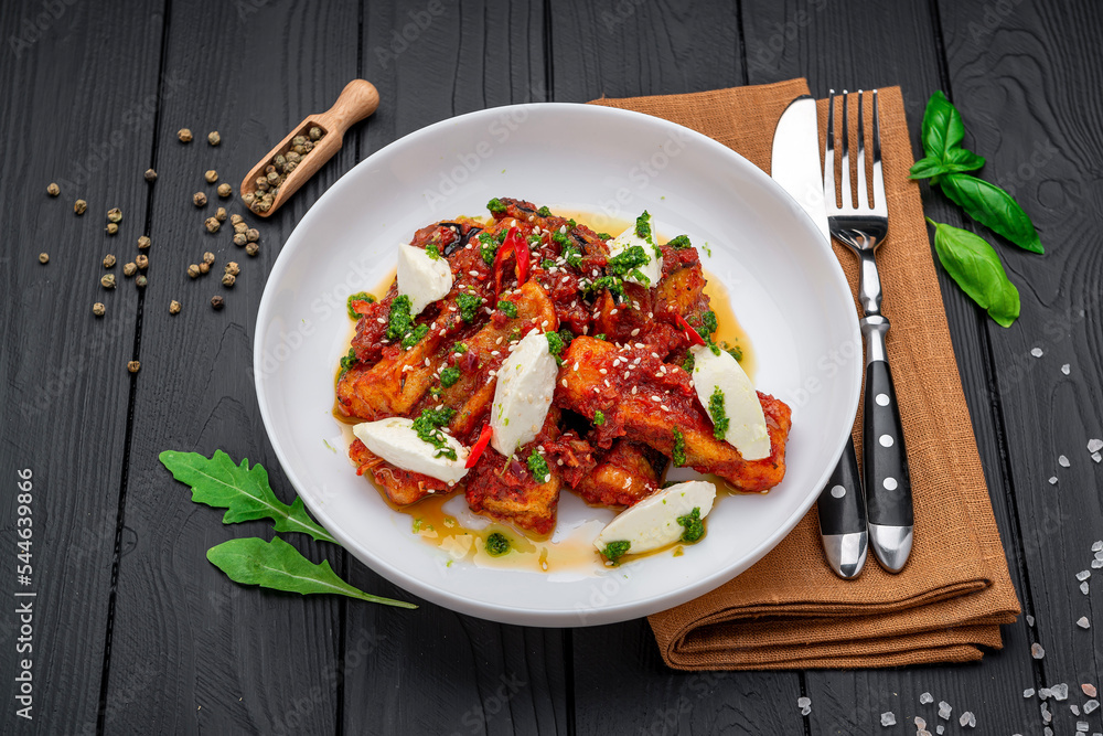 Fried eggplant slices in spicy tomato sauce with cream cheese. Fried eggplant slices in spicy tomato sauce with cream cheese.