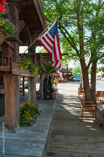 wooden sidewalk with American flags and sculptured silhouettes in western style in Winthrop, Washington State, USA