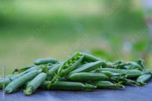 Composition with green peas on a wooden surface.