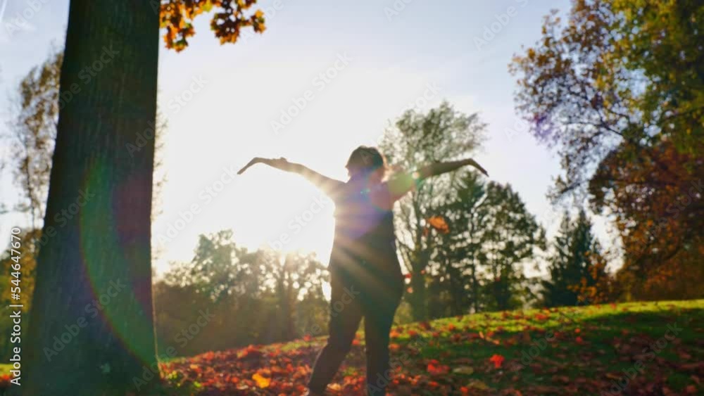 Happy Woman Throwing Up in the Air Autumn Leaves with Sunbeam and Lens Flare in a Sunny Day in Switzerland. Happy Woman Throwing Up in the Air Autumn Leaves with Sunbeam and Lens Flare in a Sunny Day in Switzerland.