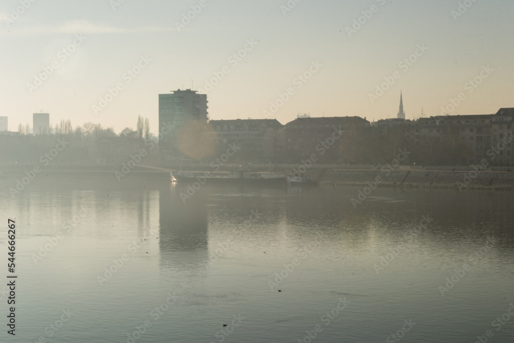 A panoramic view of the buildings next to the Danube River. Buildings by the Danube in winter, illuminated by the sun.