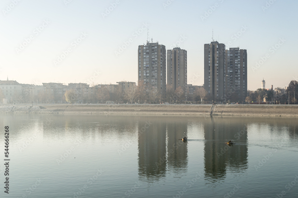A panoramic view of the buildings next to the Danube River. Buildings by the Danube in winter, illuminated by the sun. A panoramic view of the buildings next to the Danube River. Buildings by the Danube in winter, illuminated by the sun.
