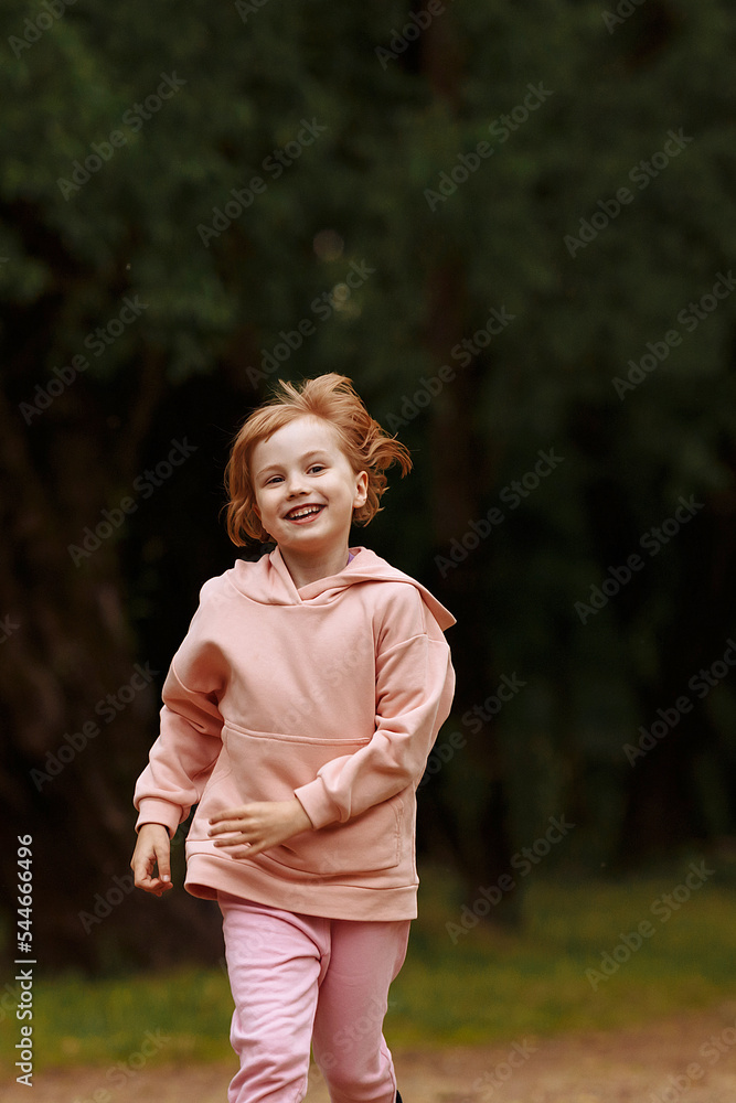 A girl in pink runs through the park A girl in pink runs through the park