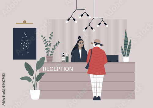 A hotel receptionist desk decorated with paintings, light, and plants, a senior lady checking in