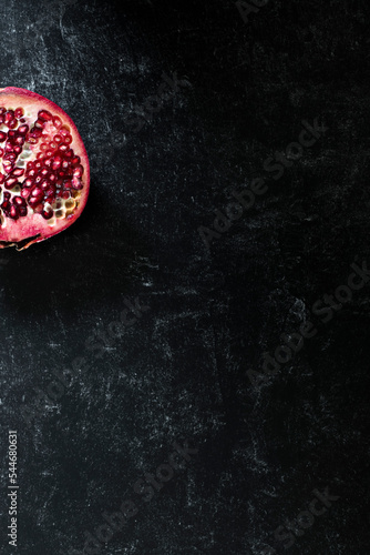 Minimal Pomegranate Slice on dark black tabletop